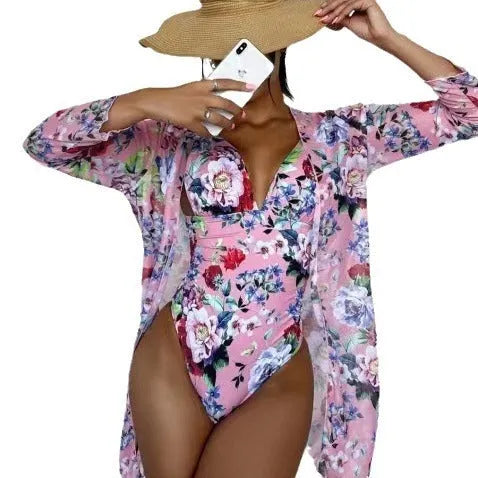 Women's floral print bikini and matching coat three-piece swimsuit set on a hanger.