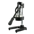 Tall black cast iron manual juicer with stainless steel cone on a kitchen counter