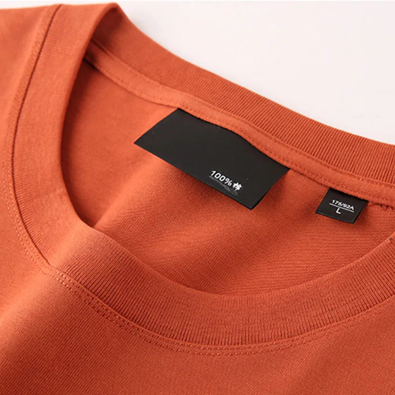 Man wearing a solid colour loose-fit cotton T-shirt with drop shoulder sleeves.
