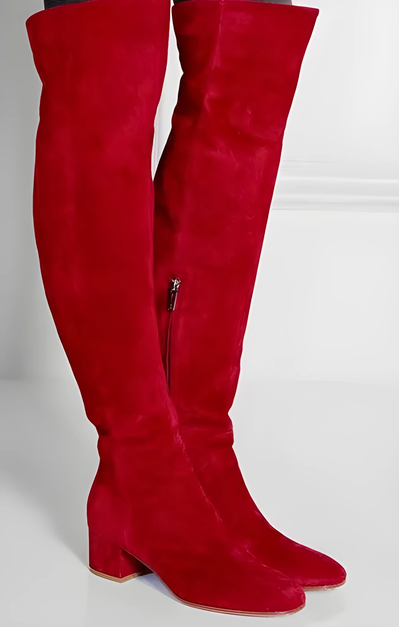 Women's grey suede over-the-knee flat boots with a pointed toe and low thick heel on a neutral background.