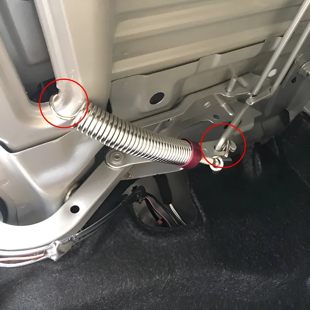 Red car trunk lift spring made from high-strength alloy weighing 130g on a surface