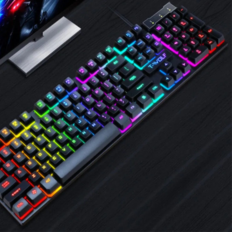 USB wired gaming keyboard with floating keycaps showing colourful backlight and multimedia shortcut row on a desktop