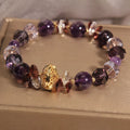 Purple crystal bracelet with pumpkin beads, wind chime charms, and rhinestone details on wrist