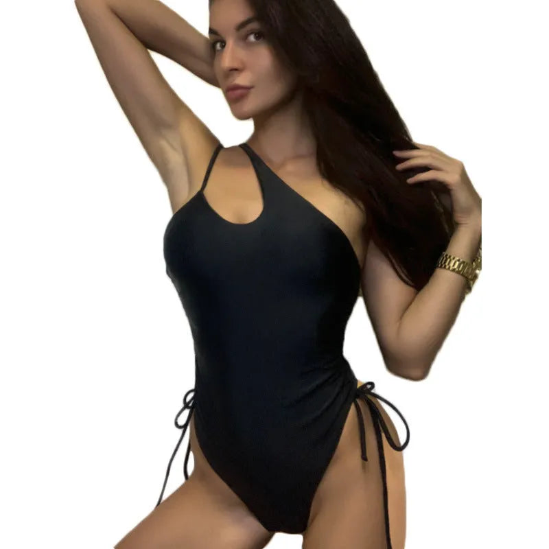 Black tight-fitting women's dress with sloping shoulders and decorative lacing detail, sleeveless design.