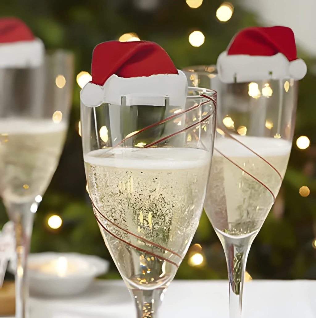 Set of 10 red non-woven fabric Santa hat decorations for wine glasses on a party table