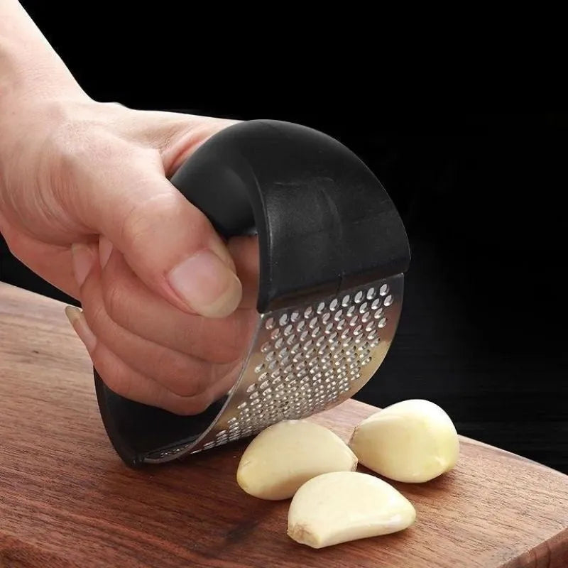 A stainless steel garlic press with a curved design and non-slip ergonomic handle.