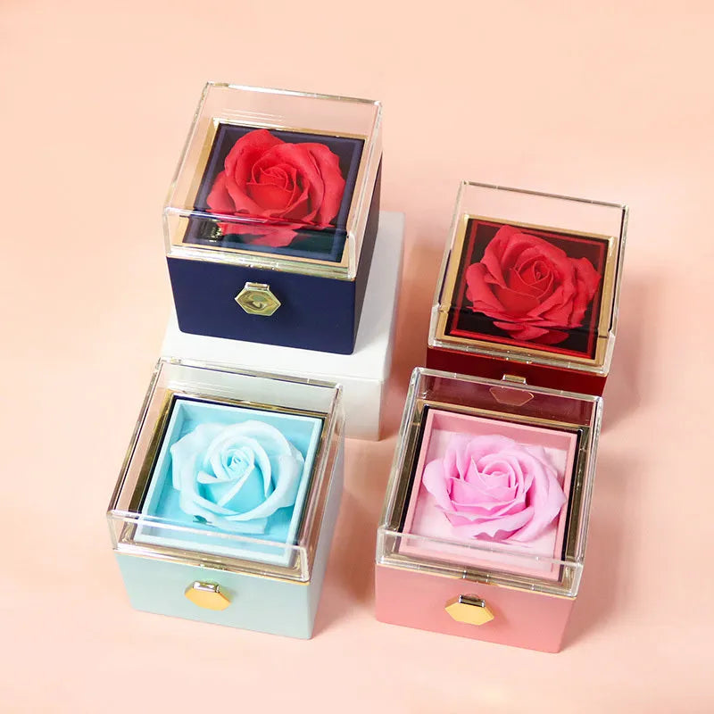 Rotating jewellery box with preserved red rose under acrylic cover and drawer open showing storage