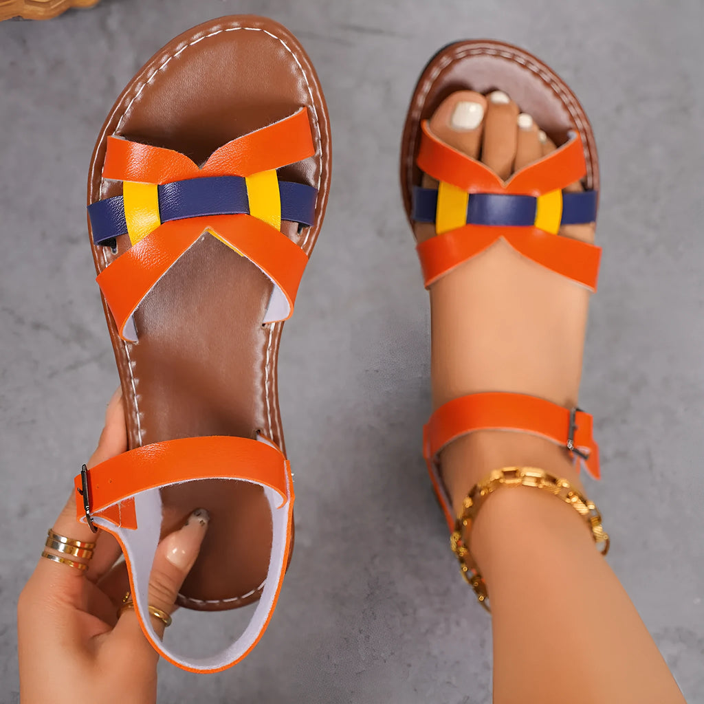 Women's orange buckle sandals with round toe, PU upper, and rubber sole on a neutral background