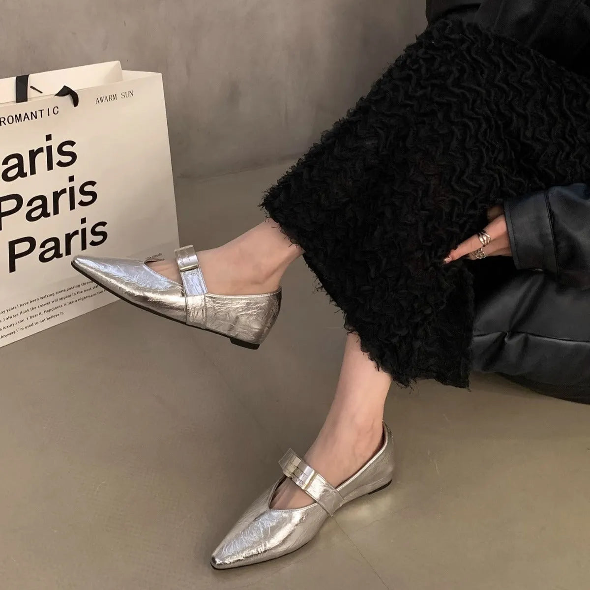 Women's black Mary Jane shoes with pointed toe, silver buckle, and low heel