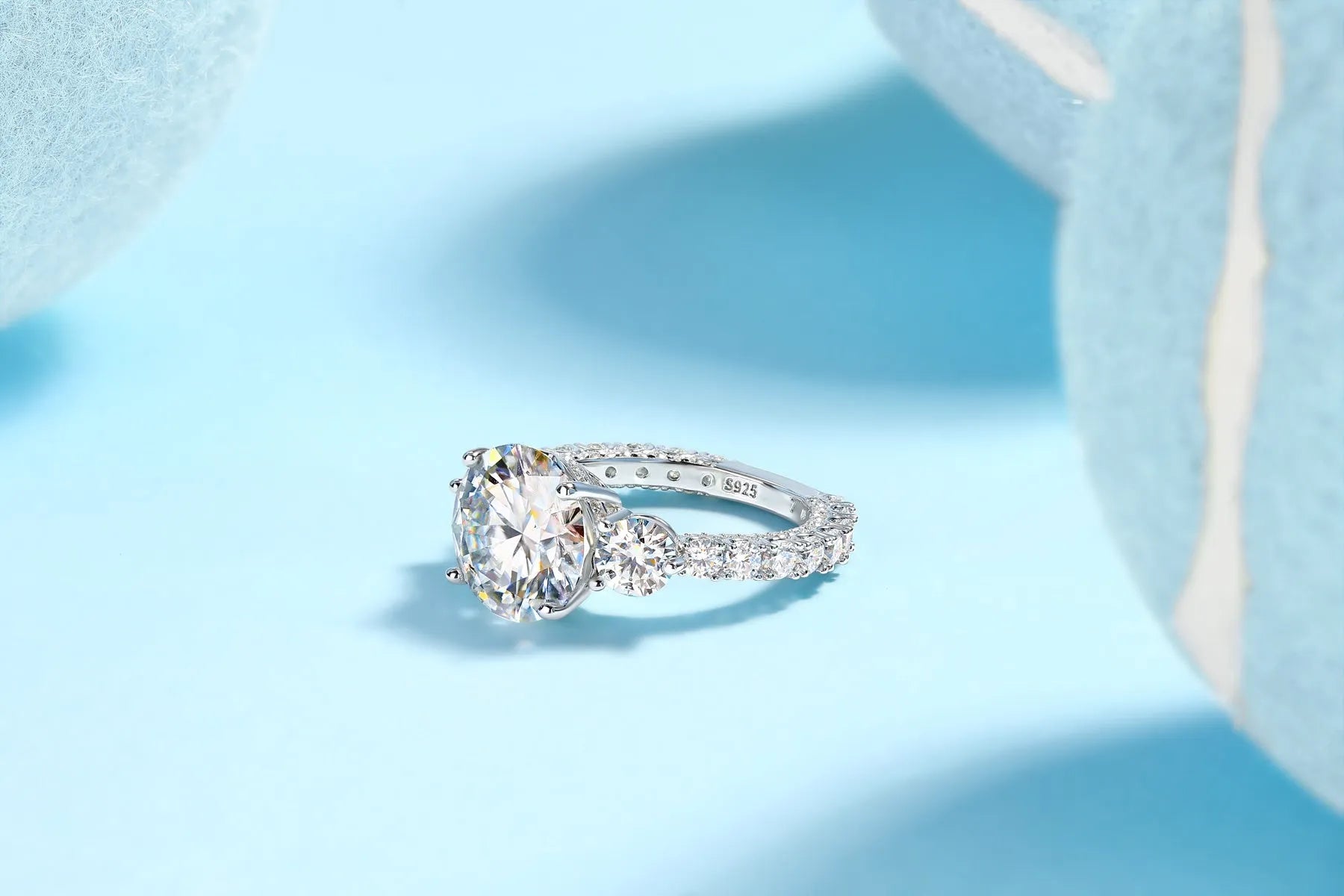 Three-diamond moissanite wedding ring with 5-carat stone, S925 silver band, platinum plating, on a white background