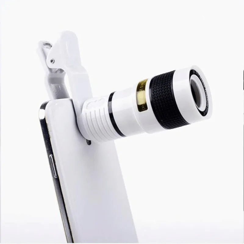 A black 12X phone telescope lens next to a universal mounting clip and cleaning cloth on a table.