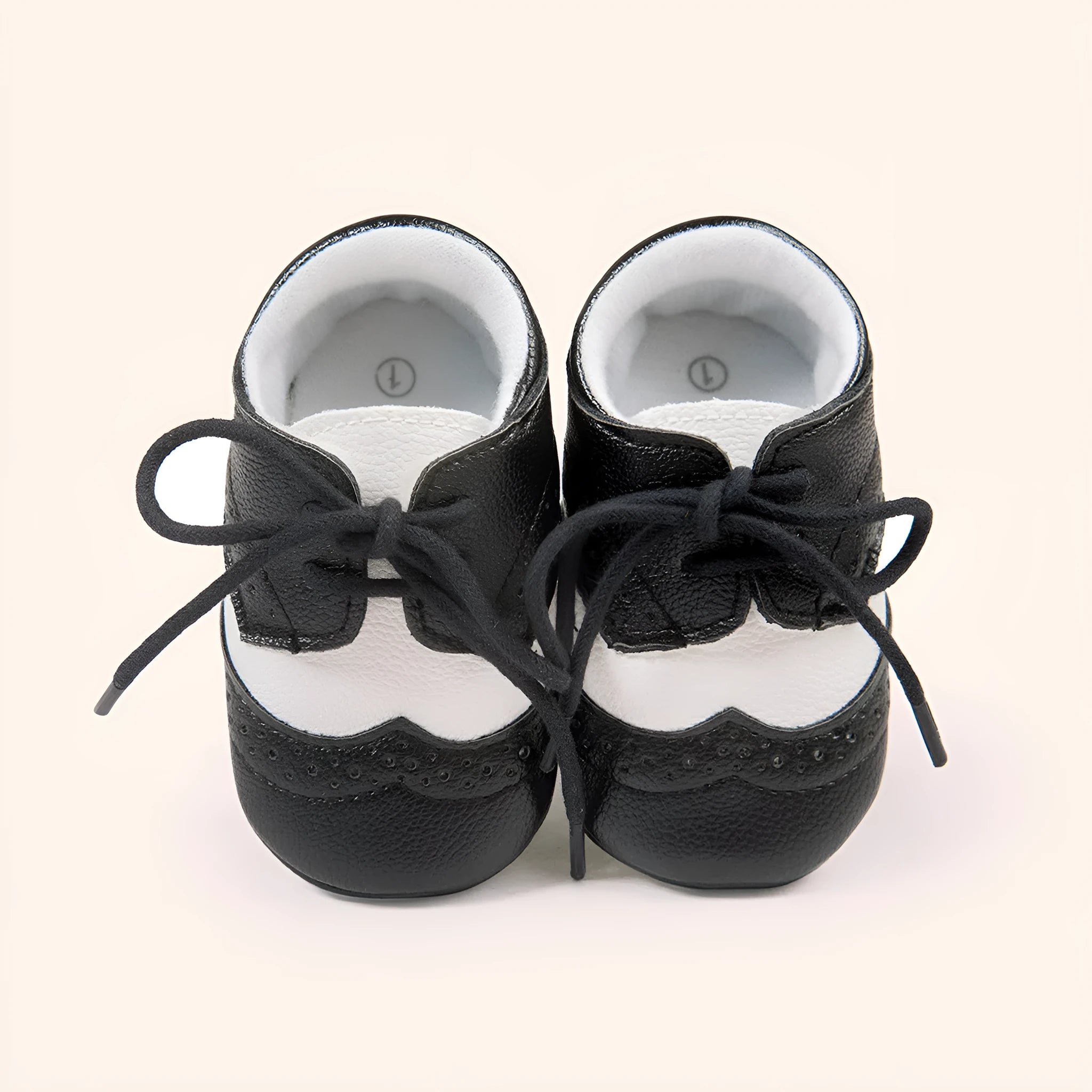 Vintage-style soft-soled baby shoes in synthetic leather, shown in light brown.