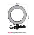 Black 20cm LED ring light kit with tripod, selfie stick, and phone clip on a desk