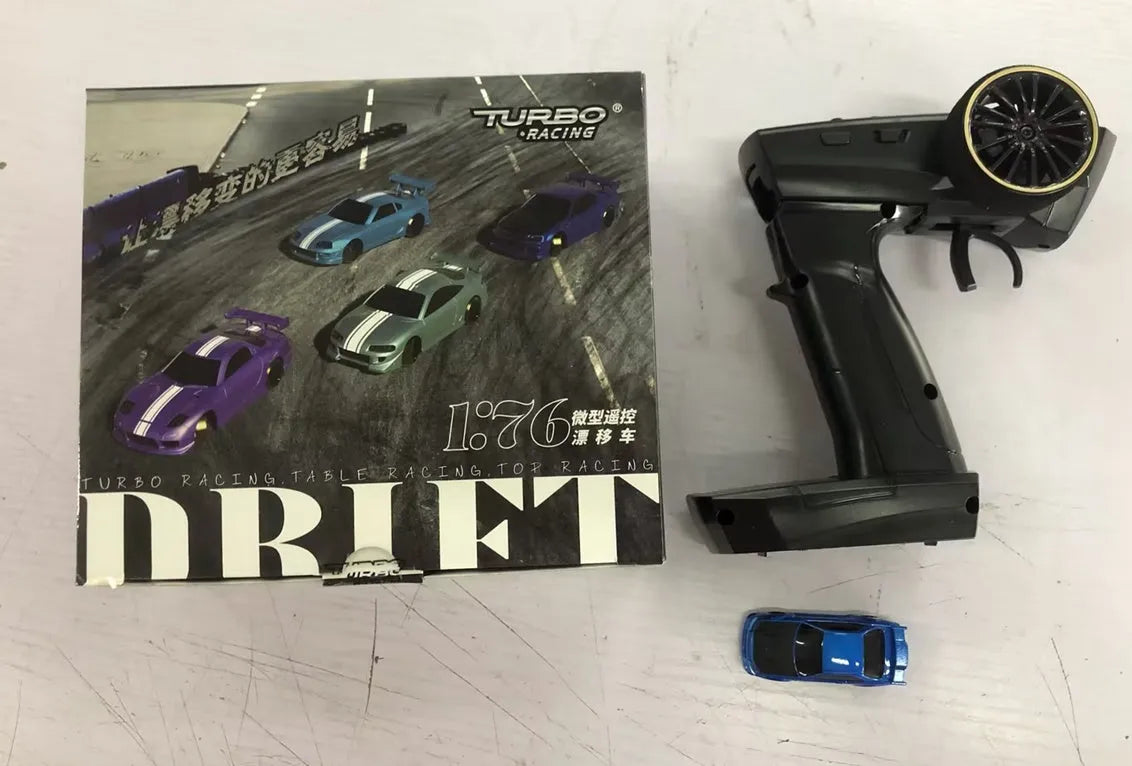 Turbo Racing C64 blue RC drift car with proportional remote control on racing track