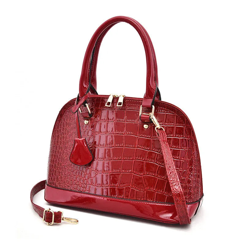 Shiny black PU leather crossbody shoulder bag with a structured shell shape