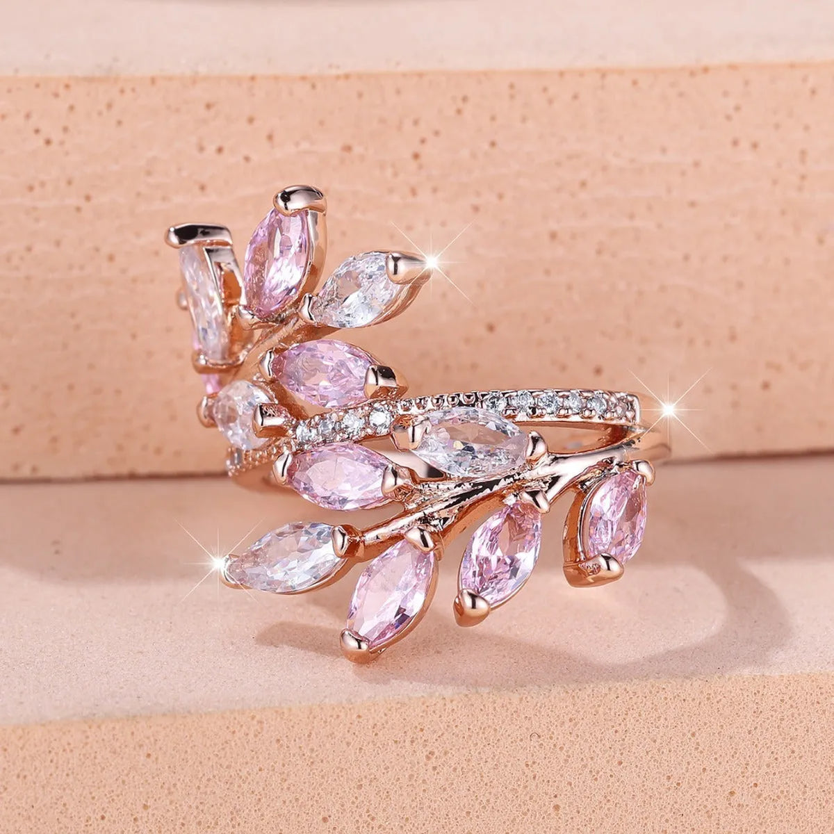 Adjustable copper leaf ring with a horse eye zircon stone in multiple colour finishes on a neutral background.