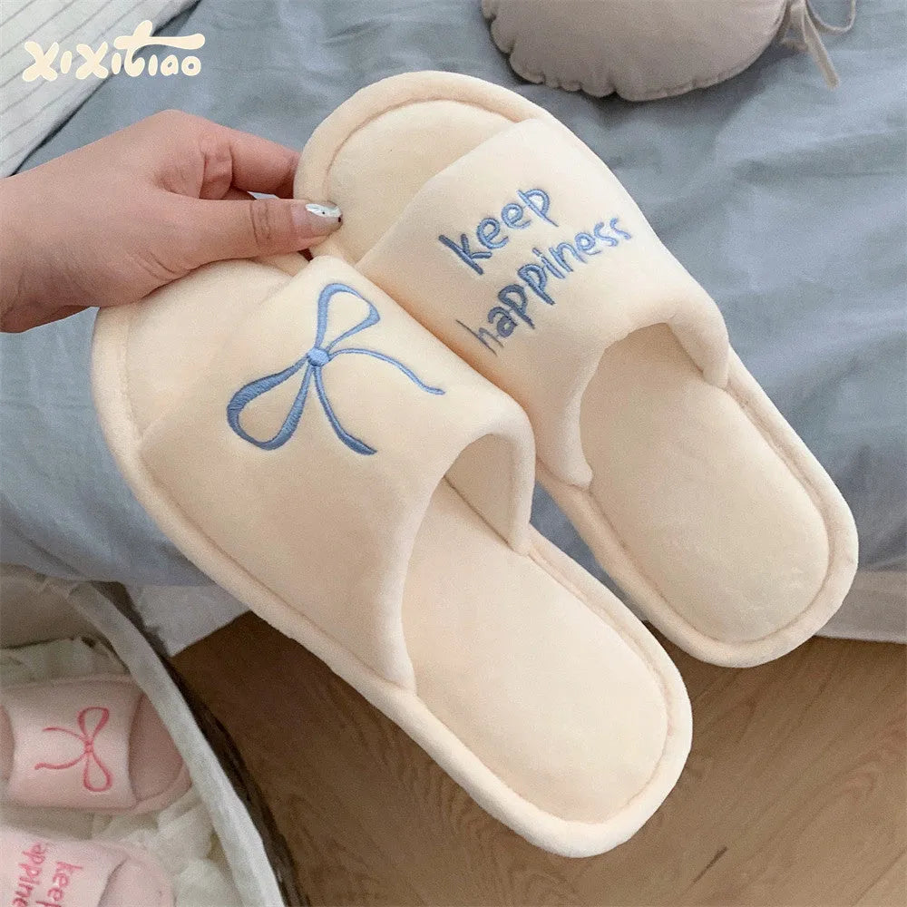 Ladies cotton slippers with suede upper, artificial wool lining, flat non-slip PVC sole, bow and letter detail, beige yellow pink black