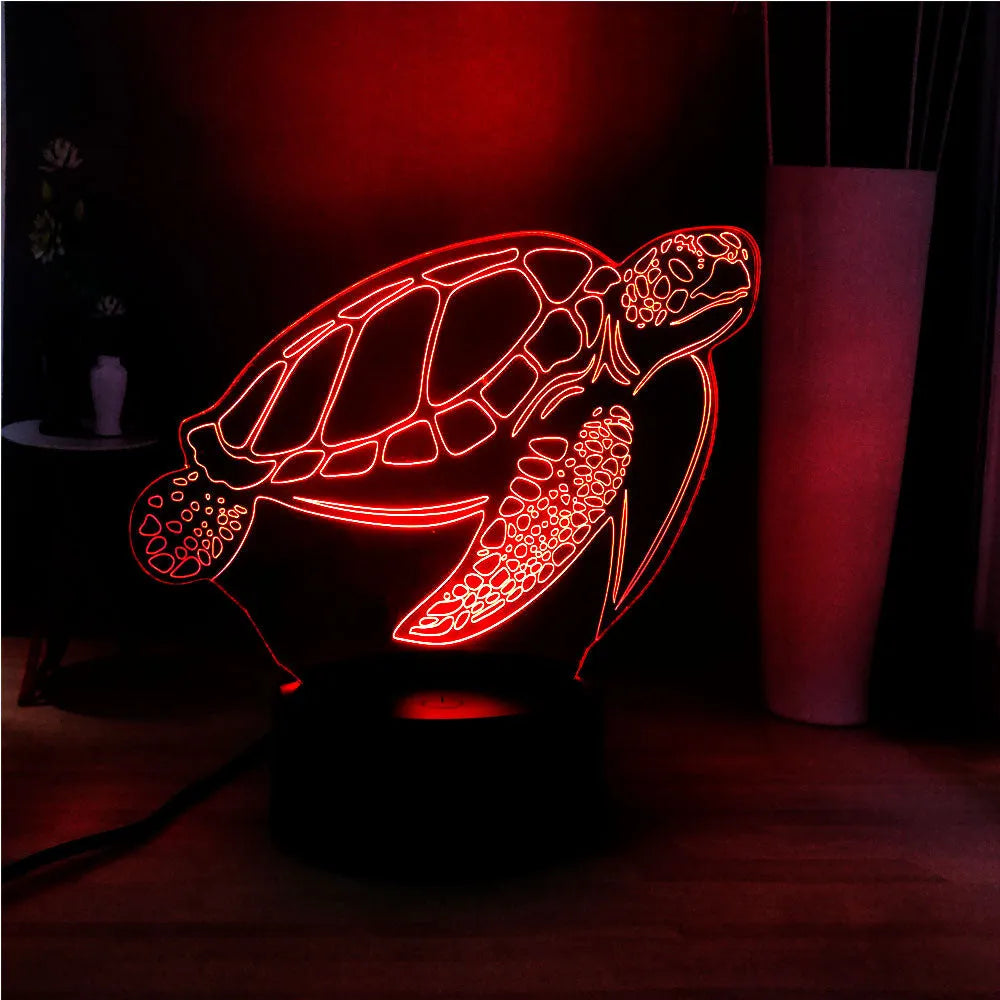 3D clear acrylic turtle-shaped LED night light with remote control on a desk.
