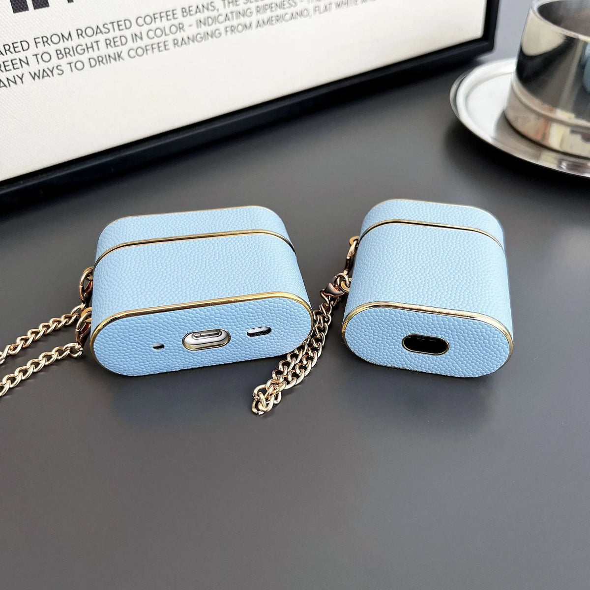 TPU protective cover for AirPods in black with frosted finish and chain attachment.