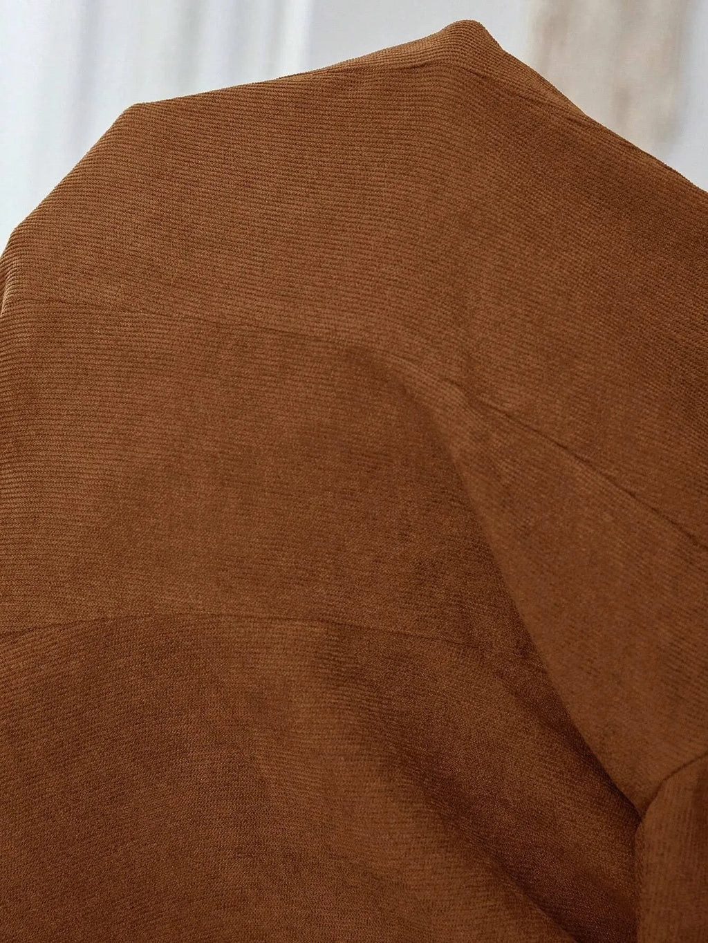 Brown single-breasted leisure suit coat with lapel collar and long sleeves laid flat.
