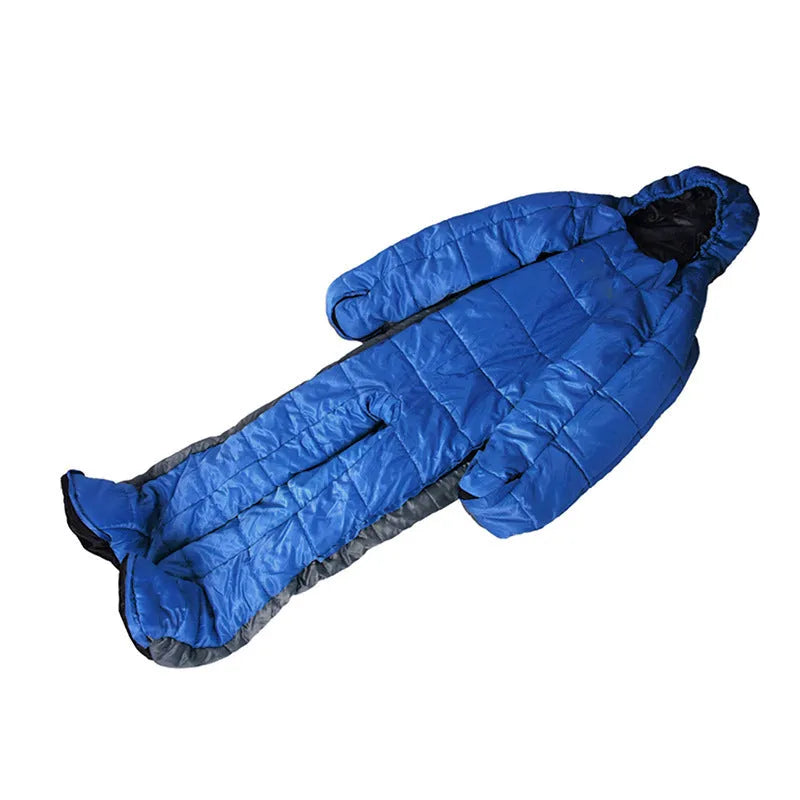 Blue gray patchwork humanoid sleeping bag on grass, legs separated for walking, mummy hood zipped with fill visible.