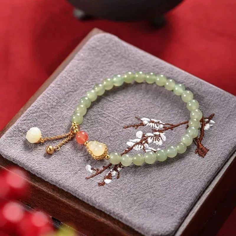 Women's jade bracelet with a 6mm gold-plated gourd charm and engraved fu character.