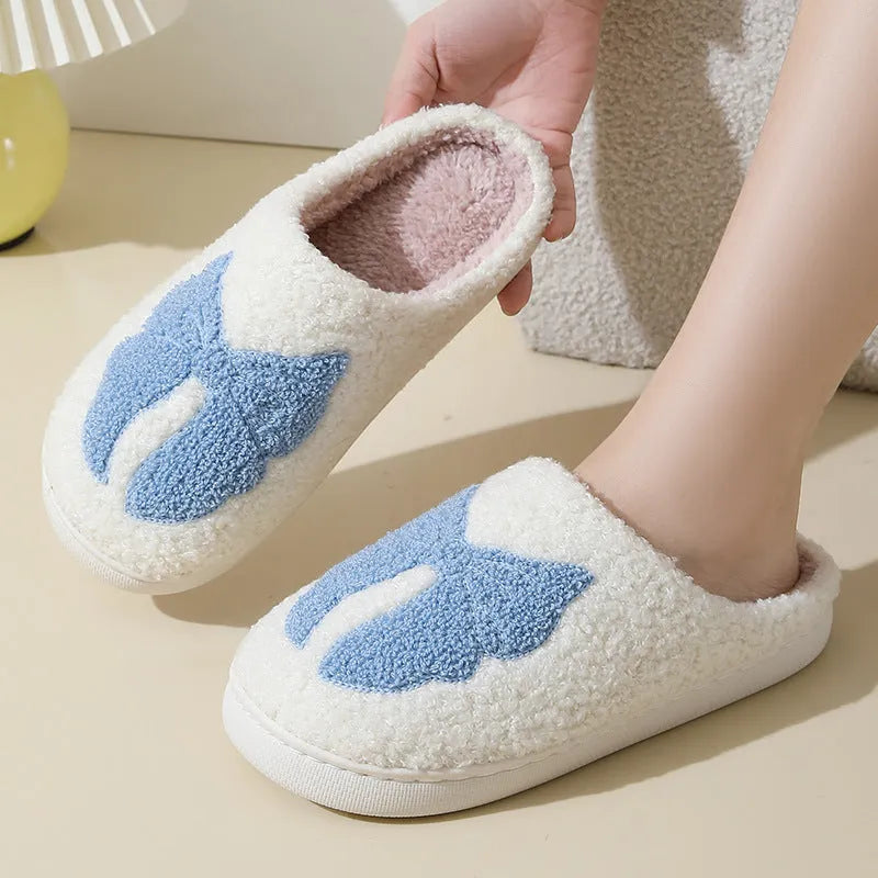 Cotton slippers with cartoon bow knot design on suede upper in pink or blue colours with TPR sole