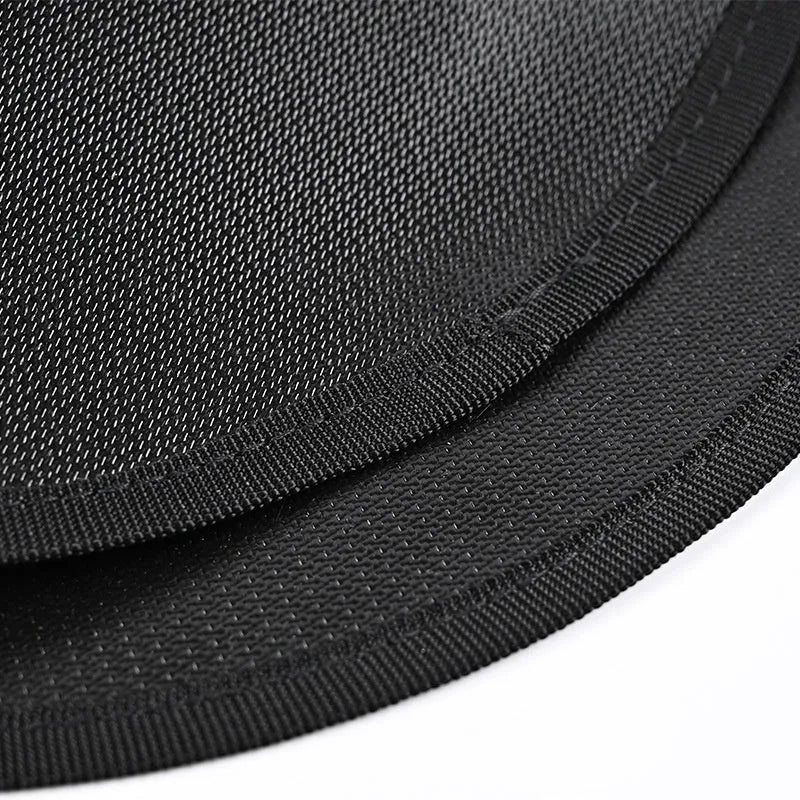 Black round barbecue fireproof mat with oil-resistant surface on a garden patio