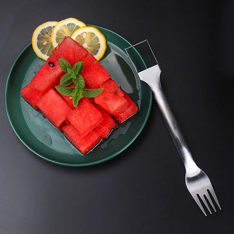 Silver stainless steel watermelon slicer with a 26cm handle and a 3.6cm wide rounded fork head.