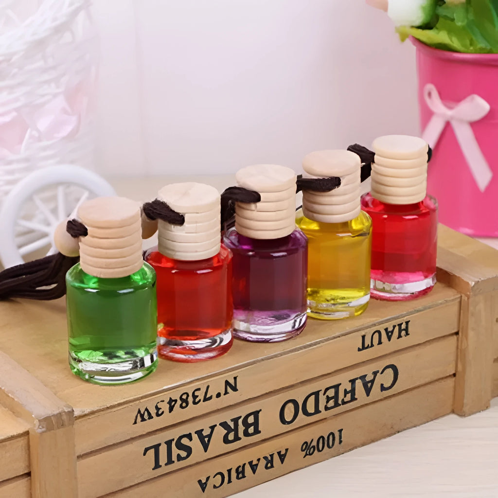 Glass bottle car air freshener hanging ornament showing six fragrance options: lavender, lemon, apple, strawberry, ocean, and floral