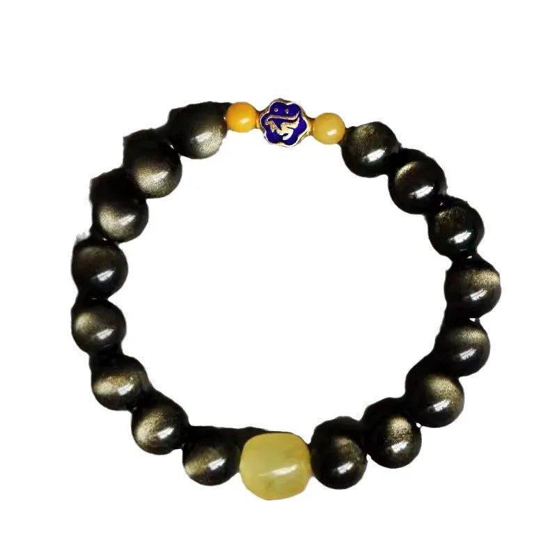 Handmade golden obsidian bracelet with geometric beads and zodiac charm on wrist.