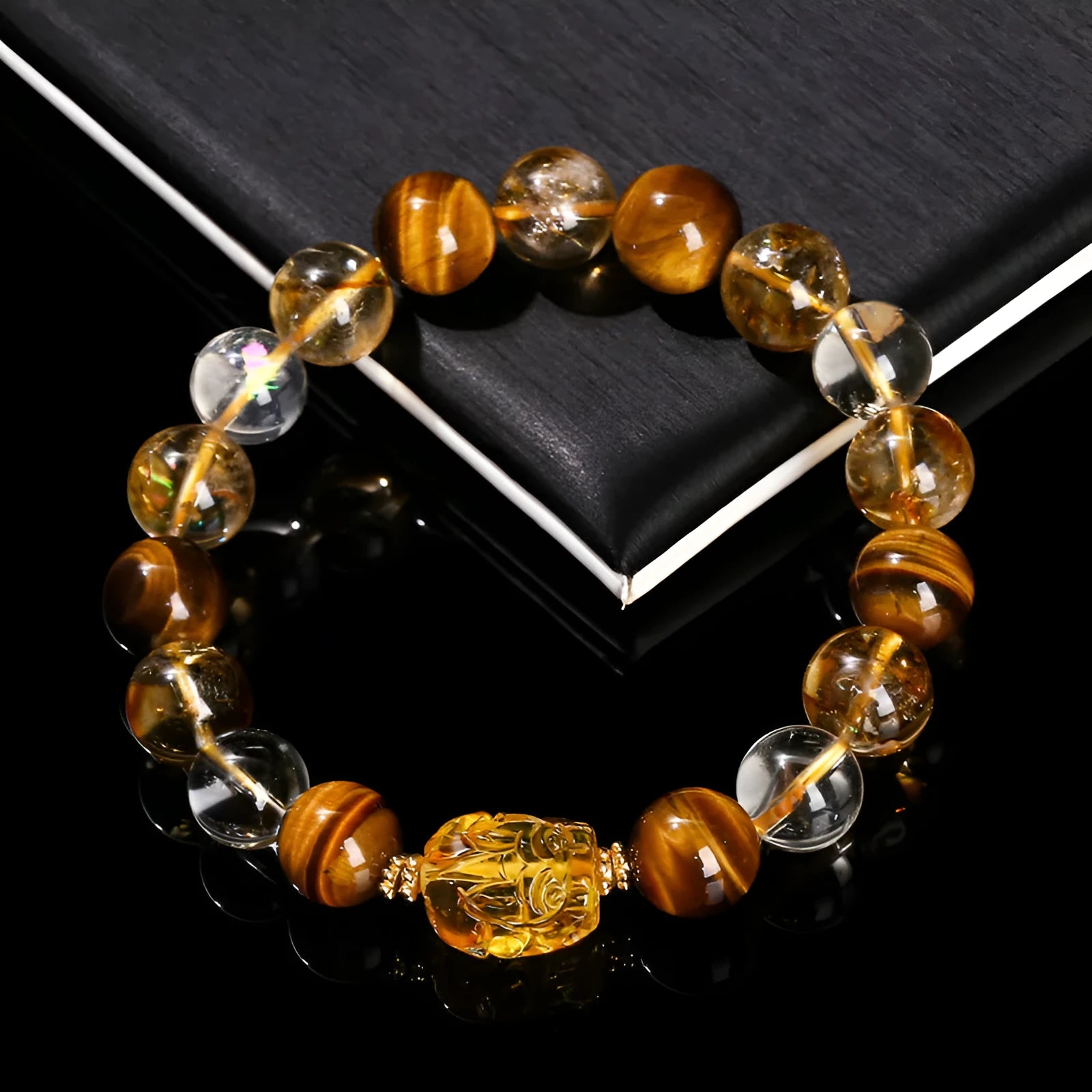 Close-up of a yellow tiger's eye and citrine gemstone bracelet with 10mm round beads and a steel clasp.