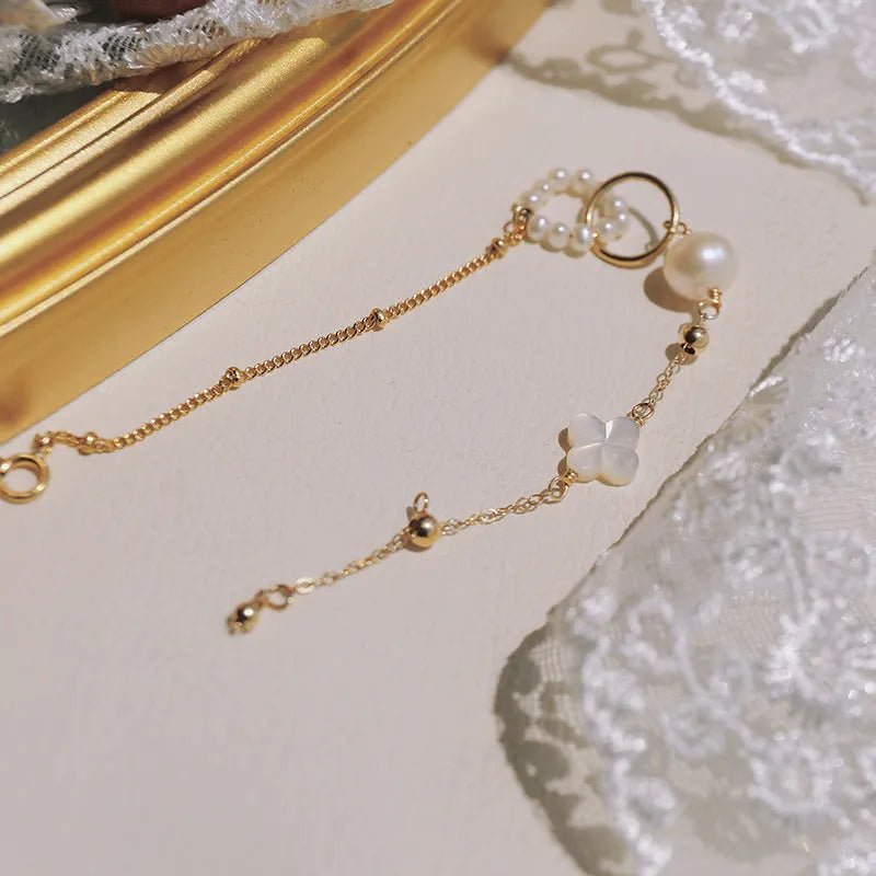 Women's natural pearl and gold-plated chain bracelet on a white background.