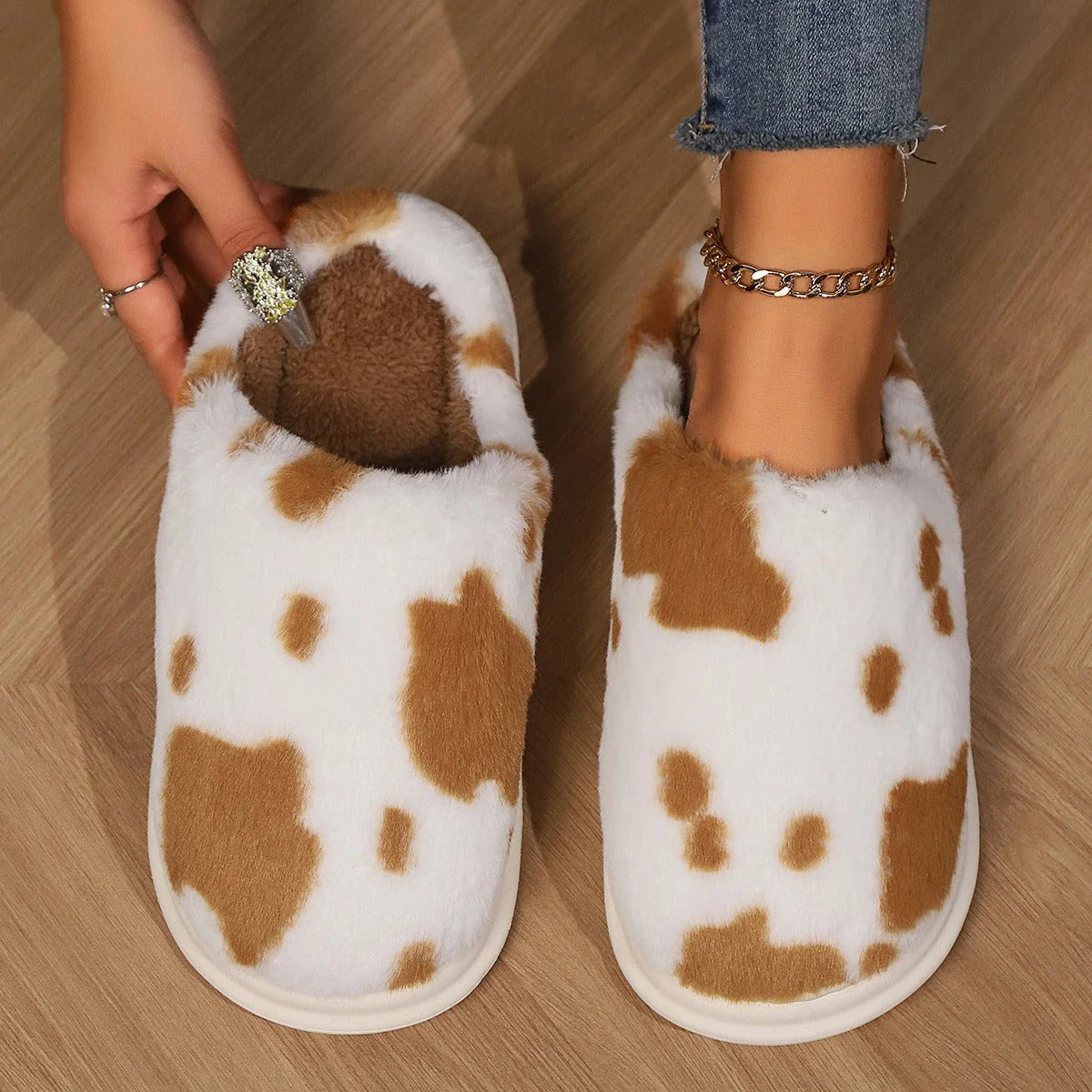 Cozy cow-print plush slippers with soft, fluffy material and non-slip soles for warm, comfortable indoor wear