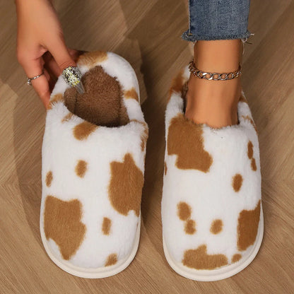 Cozy cow-print plush slippers with soft, fluffy material and non-slip soles for warm, comfortable indoor wear