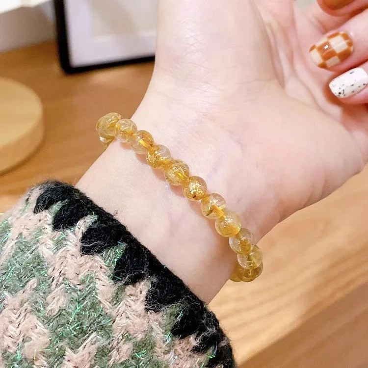 Gold rutilated quartz sunstone bracelet with round beads and diamond-shaped elements