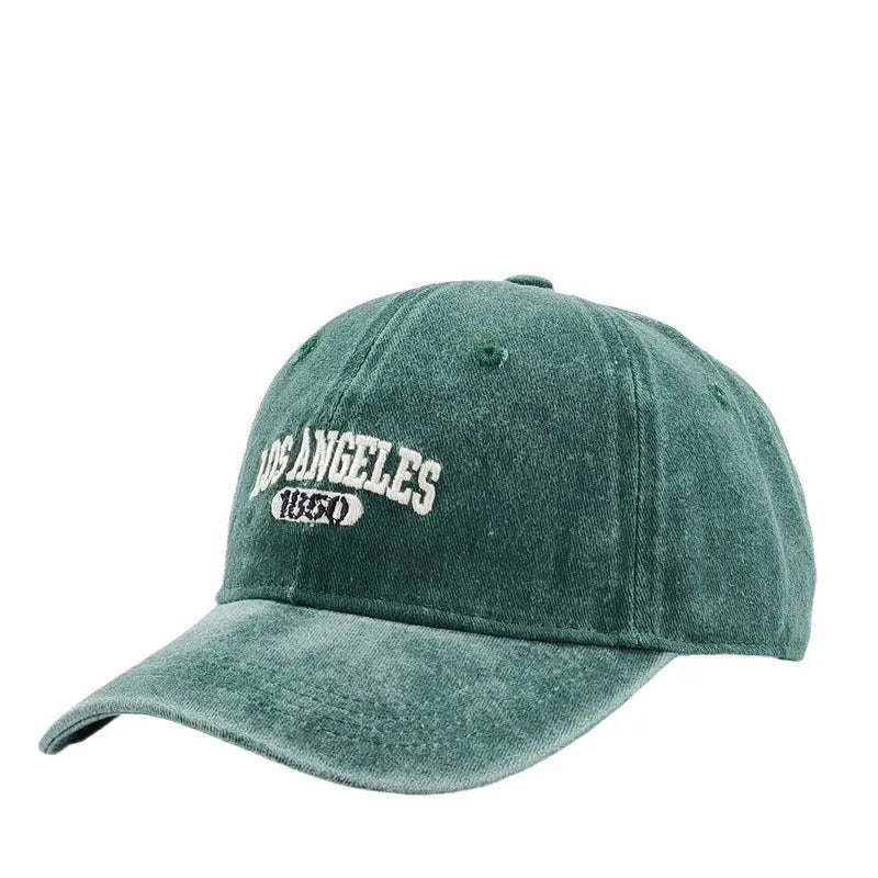 Retro distressed acrylic cap with embroidered letters, shown in beige colour with adjustable strap.