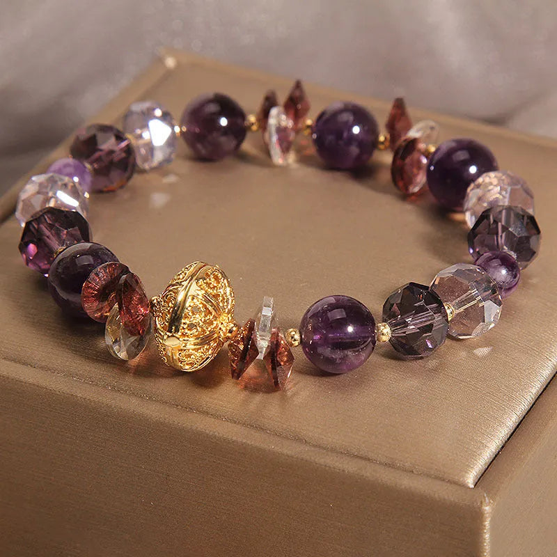 Purple crystal bracelet with pumpkin beads, wind chime charms, and rhinestone details on wrist