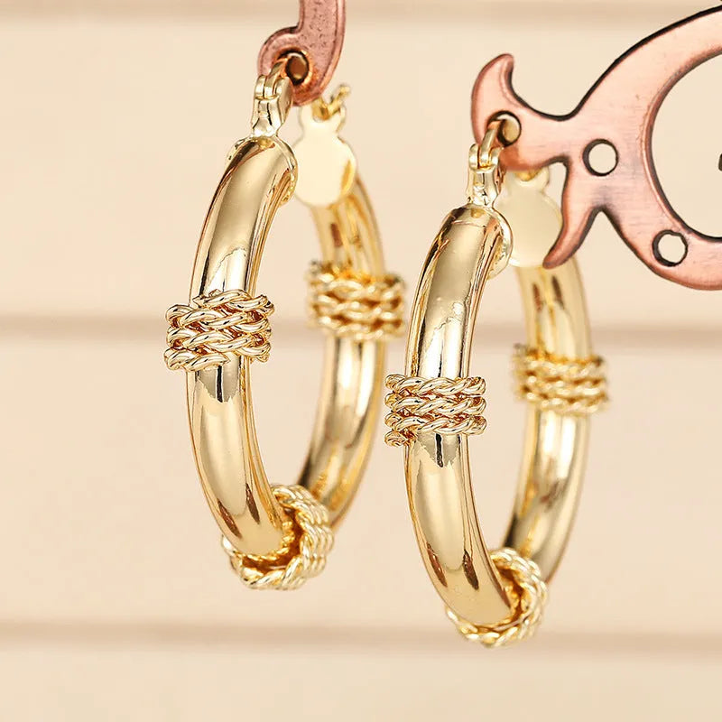 Geometric gold-coloured copper earrings with ring and line design elements