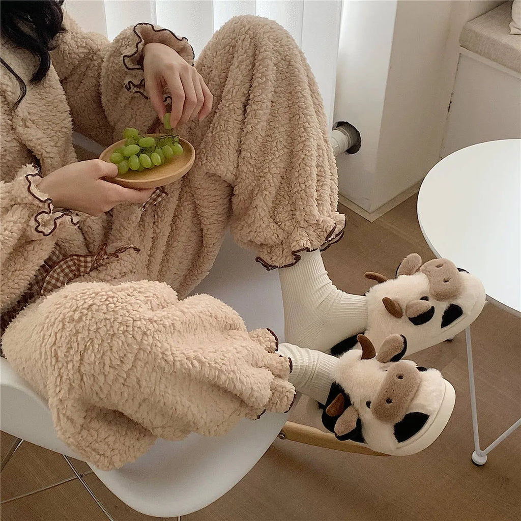 White and coffee cartoon cow slippers for women with plush faux fur and a textured non-slip sole.