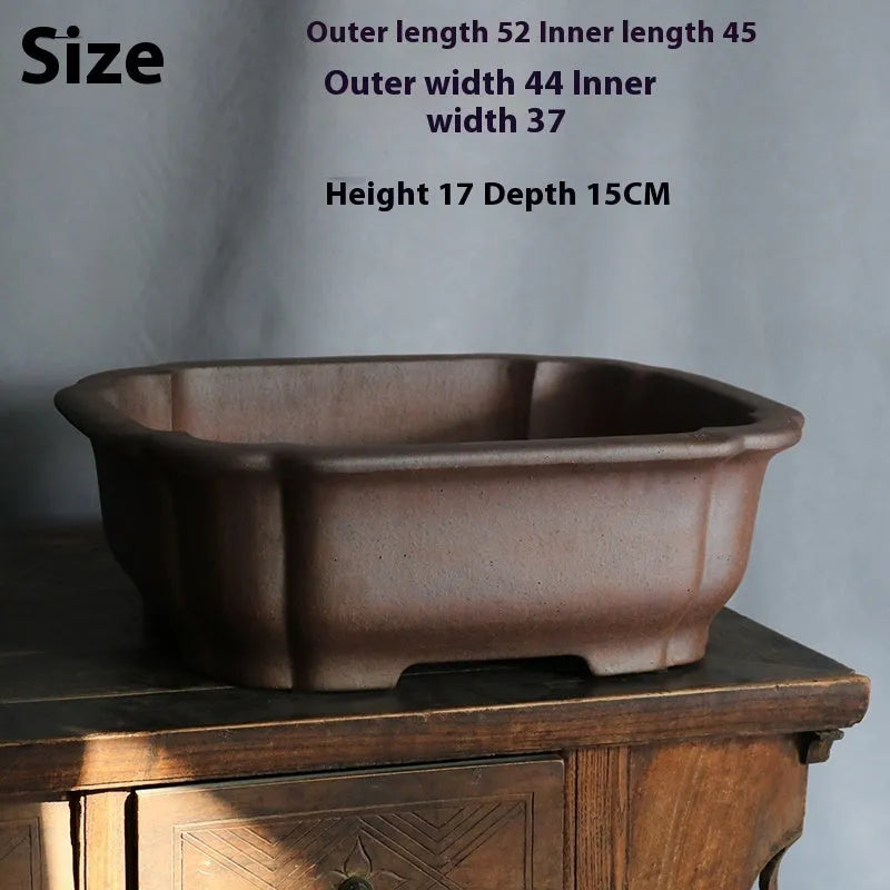 Rectangular purple sand bonsai flower pot with straight sides on a floor.