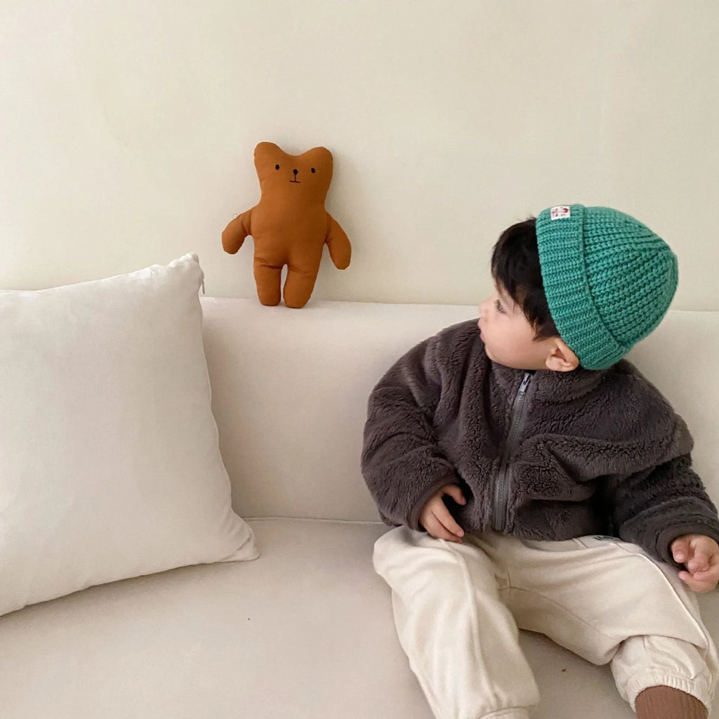 Child wearing a blue sherpa fleece zip-front winter coat with a high collar and front pockets.