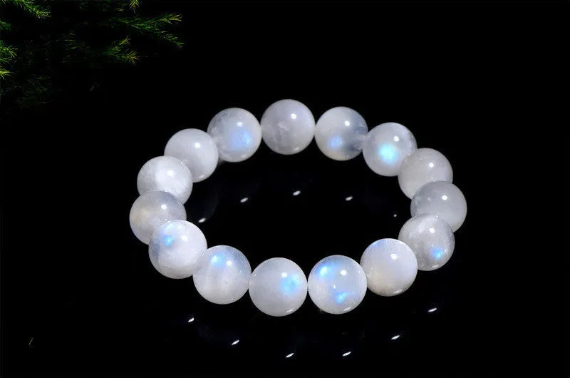 Natural blue moonlight round moonstone bead bracelet on a wrist, showing polished gemstone surface.