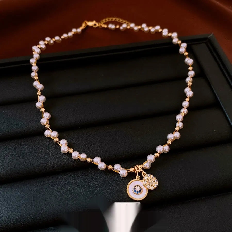 Gold and white electroplated necklace with round pearl pendant and zircon detailing on clavicle chain