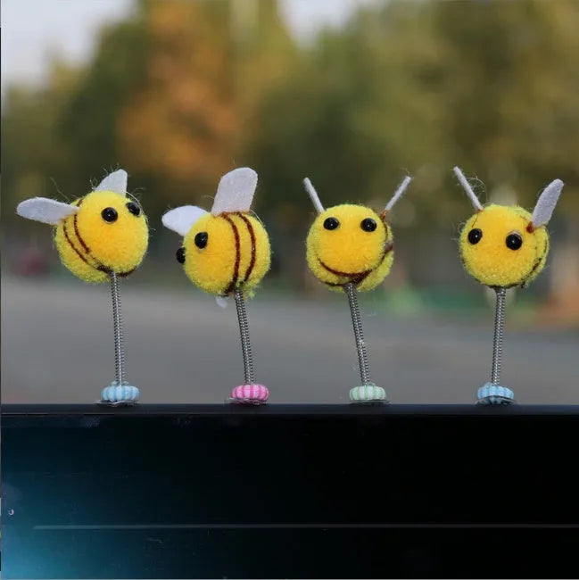 Small black and yellow cartoon bee car decoration with a spring, on a fur ball.