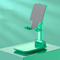 Folding telescopic mobile phone stand in white, blue, green, or pink on a desktop
