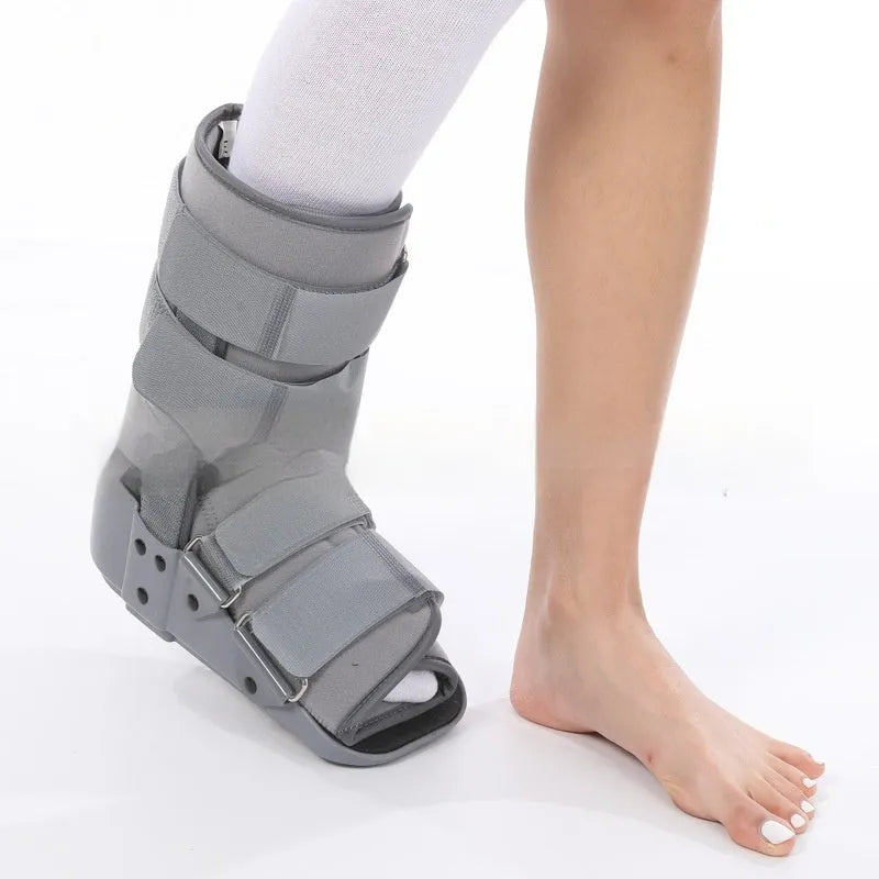 Grey Achilles tendon rehabilitation boot with aluminium frame and adjustable straps, shown with attached walking shoe.