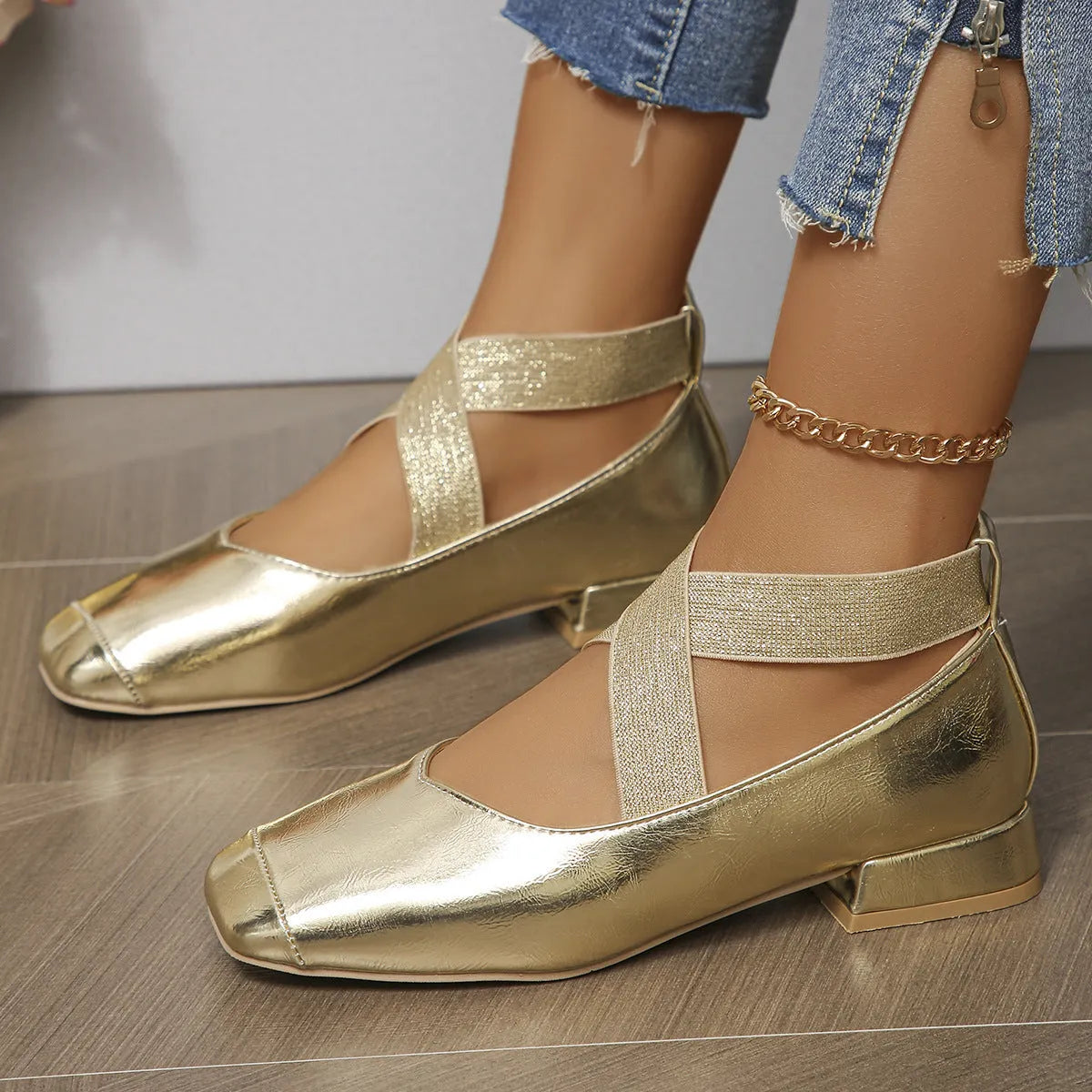 Gold French style slip-on evening pumps with square toe and low heel on a white background