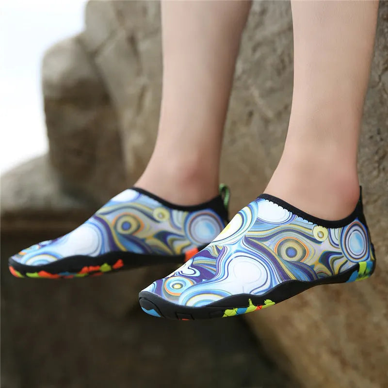 Blue Lycra beach wading shoes with EVA midsoles on a sandy background.