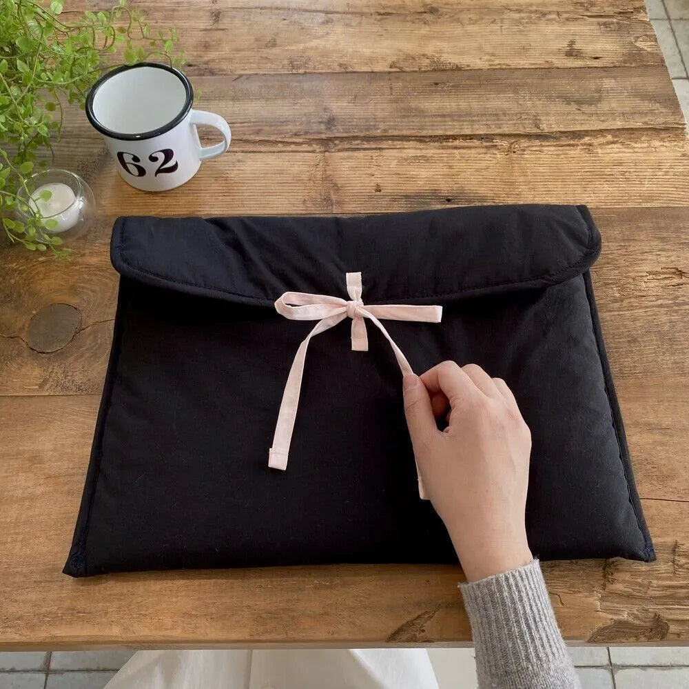 Women's black quilted laptop bag with ballet bow and striped pattern design